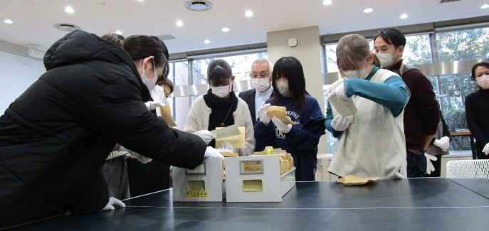 河北新報社にて_写真資料を見る学生たち_中央は堀江敏男氏(修正版)